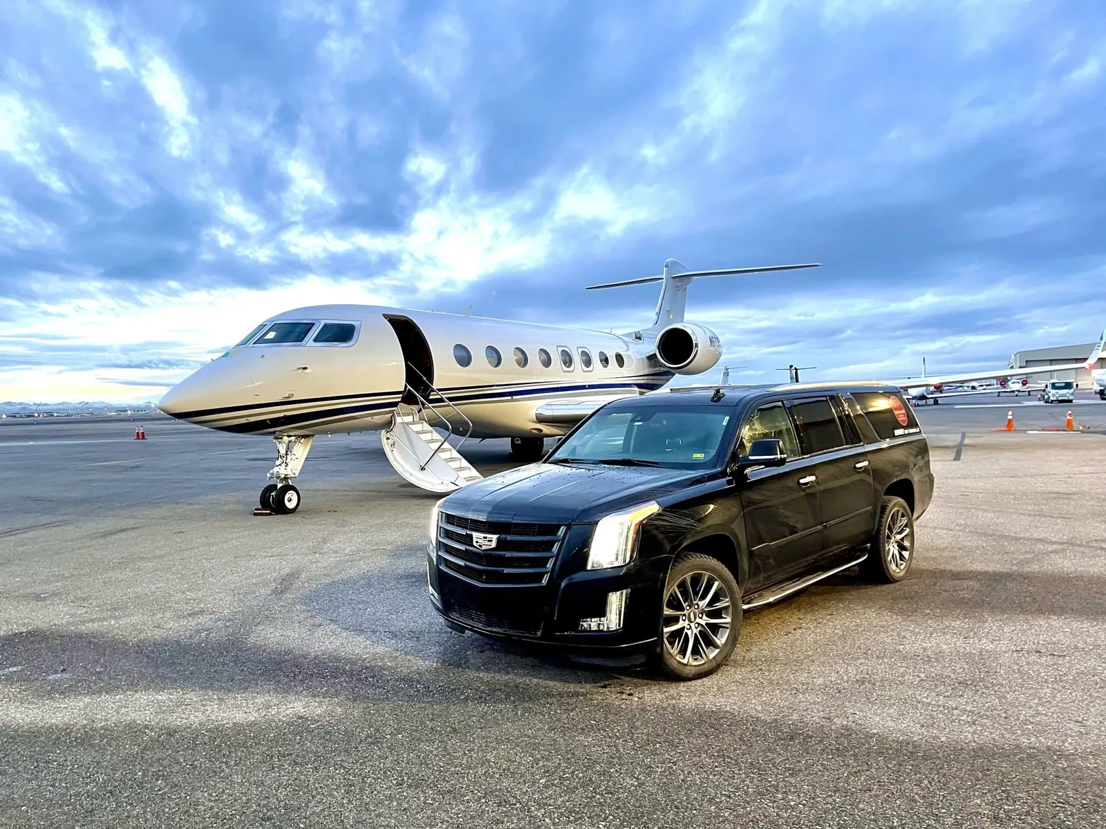 Black SUV beside a private jet on the tarmac