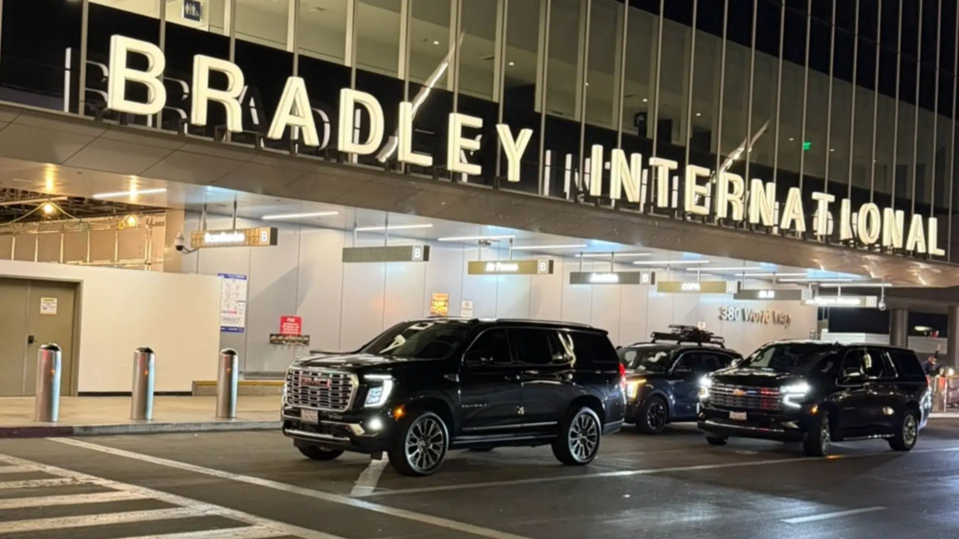 Black SUV beside a private jet at night